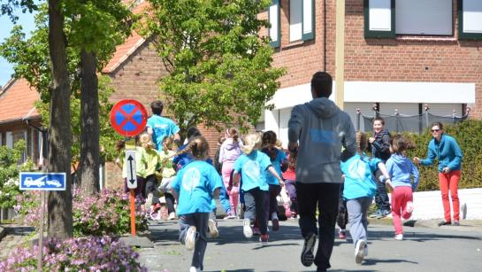 Groep kinderen die onder begeleiding lopen op straat