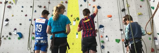 Groep jongeren op de klimmuur.